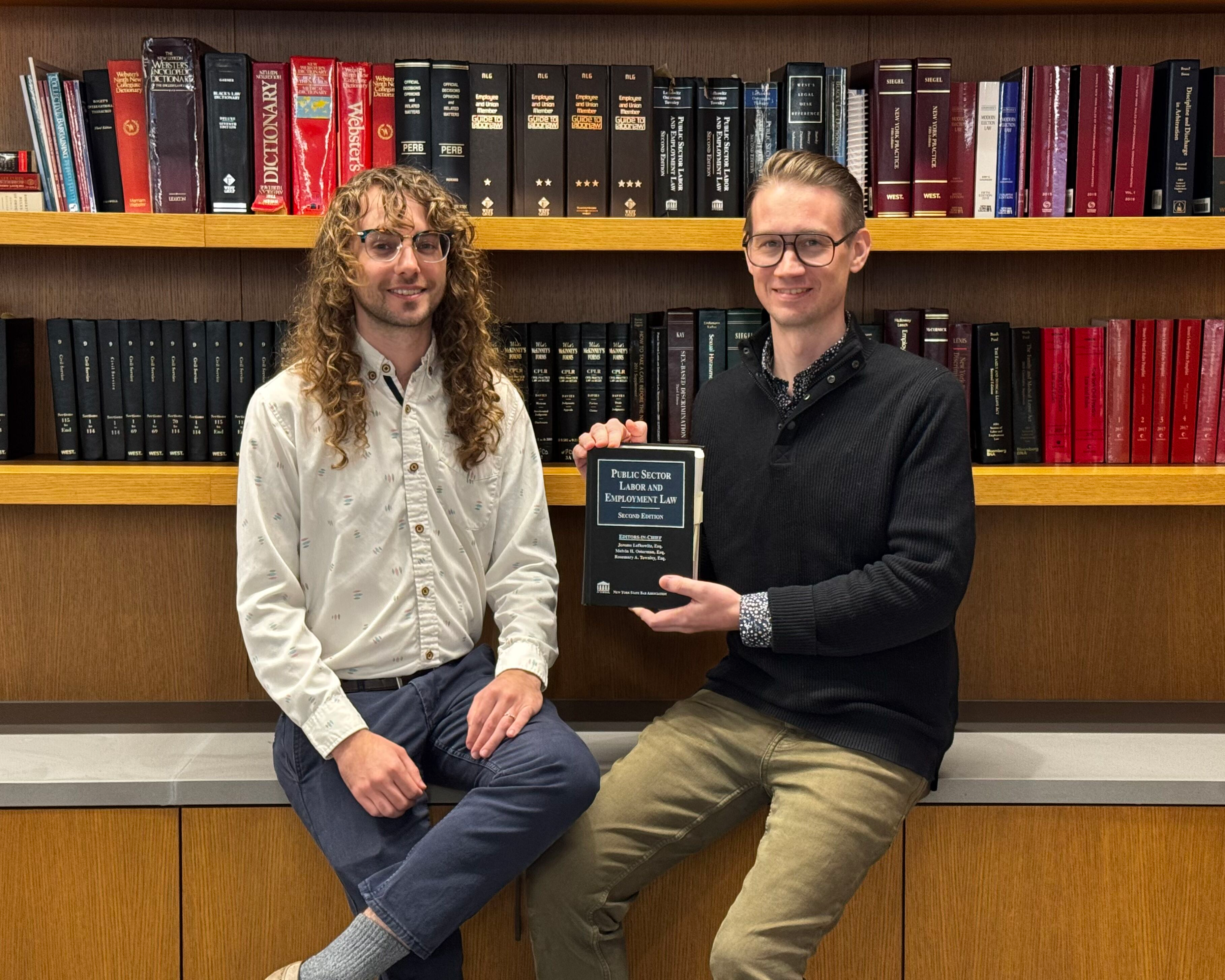 Assistant General Counsel Terry Buck and Seth York with the Lefkowitz on Public Sector Labor and Employment Law textbook they contributed to.