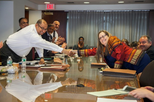 DC 37 Executive Director Henry Garrido shakes hands on tentative agreement with Pam Silverblatt of CUNY. Photo: Clarence Elie-Rivera